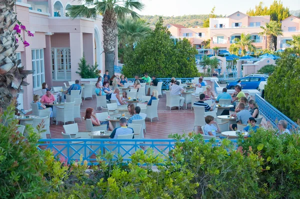 ISLA DE RHODES, GRECIA - 1 DE JULIO: Los turistas toman sus bebidas en un restaurante del hotel Mitsis Rhodos Village el 1 de julio de 2013. Isla de Rodas, Grecia . — Foto de Stock