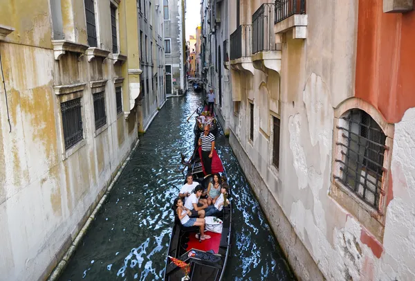 Benátky Červen 15: gondoliér spustí gondola se skupinou turistů na benátský kanál 15. června 2012 v Benátkách, Itálie. — Stock fotografie
