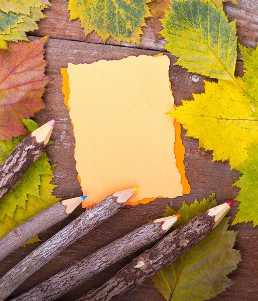 Pencils and note on wooden board — Stock Photo, Image