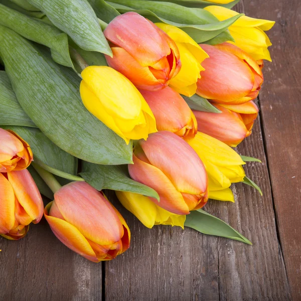 Tulipanes rosados sobre mesa de madera blanca — Foto de Stock