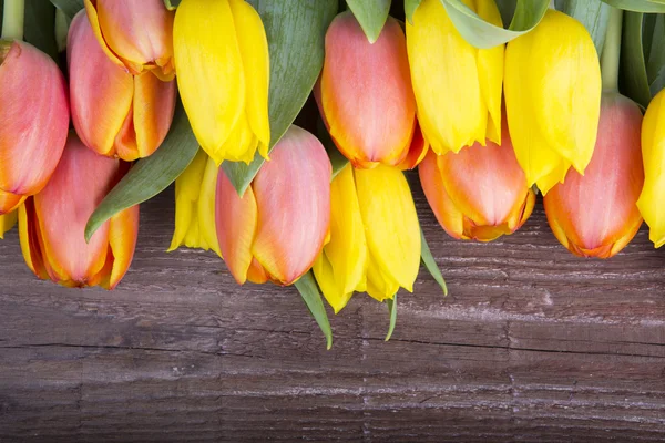 Tulipány omšelé dřevěné pozadí — Stock fotografie