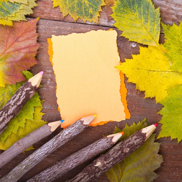 Pencils and note on wooden board — Stock Photo, Image