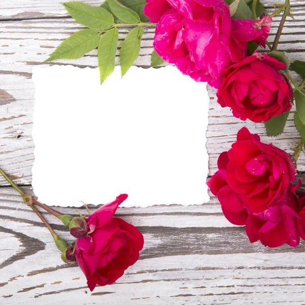 Roses avec une carte sur des planches en bois — Photo