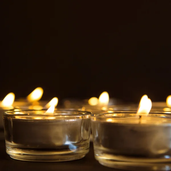 Grupo de velas acesas no fundo preto — Fotografia de Stock