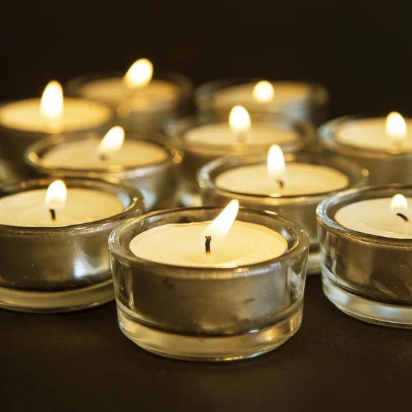 Gruppe brennender Kerzen auf schwarzem Hintergrund. lizenzfreie Stockbilder