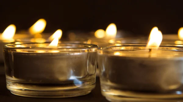 Grupo de velas acesas no fundo preto — Fotografia de Stock