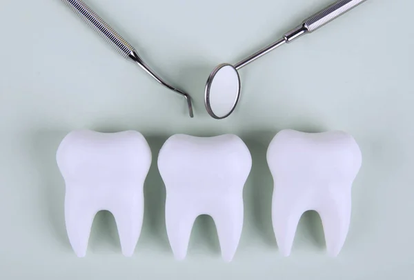 歯の鏡と歯医者の道具を持った歯 — ストック写真