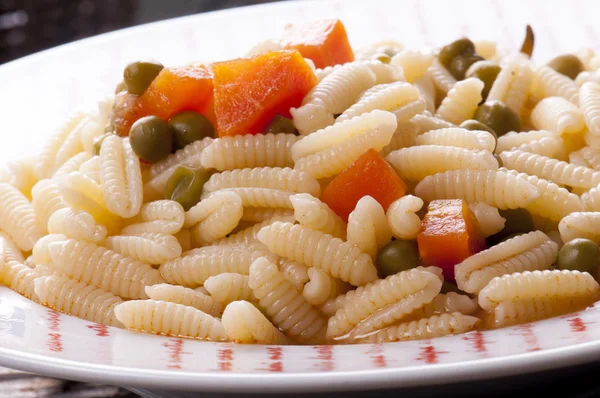 Sardinian gnocchi with peas and carrots in broth — Stock Photo, Image