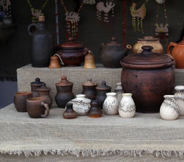 Çeşitli boyutlarda çamur bardakları ve çömlekler.