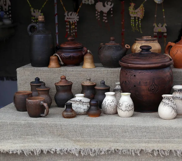 Çeşitli boyutlarda çamur bardakları ve çömlekler.