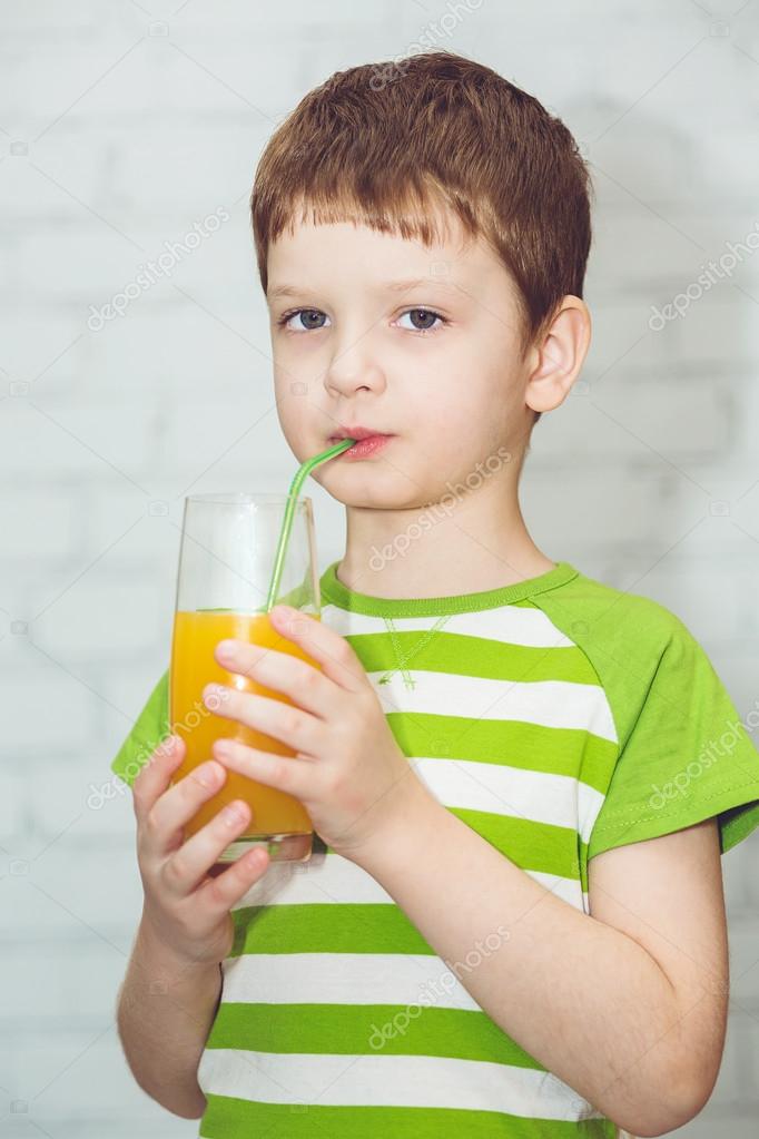 Adorable child drinking orange juice out of the tube, closeup — Stock