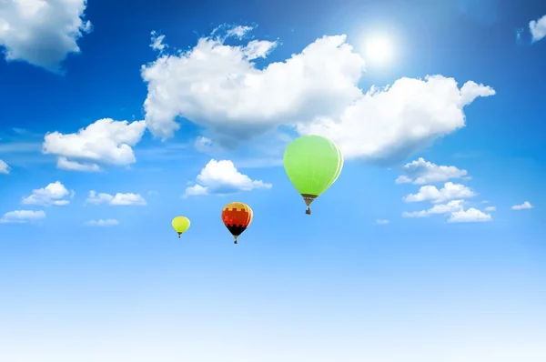 Ballonnen zonovergoten tegen een blauwe hemel en wolken. — Stockfoto