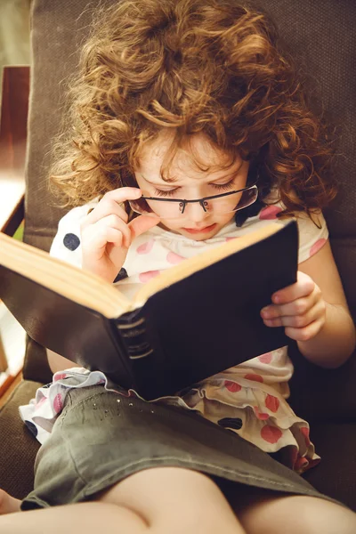 Cute girl reading a book. Photo toning in brown.