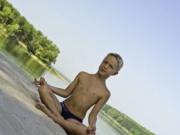 一个孩子在沙滩上打坐. — 图库照片