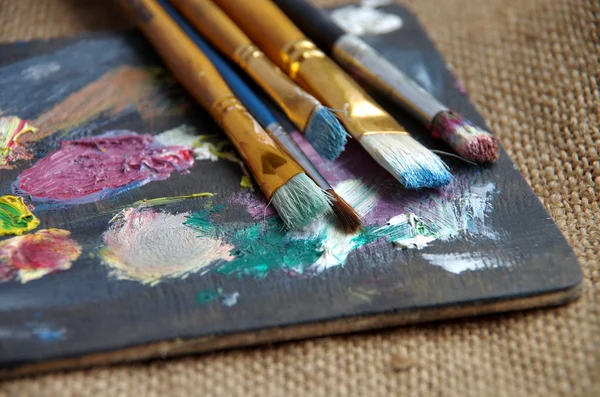 Brush in the paint on the palette — Stok fotoğraf