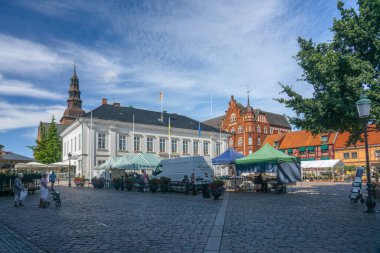Ystad, Sweden - 24, Aug 2022: Smaller town square with commerce and tents selling various things on a sunny summer day. Showing back of the tents providing commerce