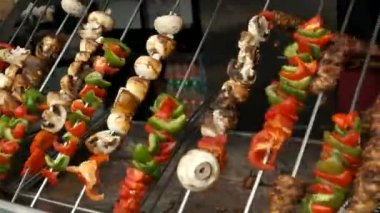 Kebap yapmak için açılmış et ve sebzeler, portatif bir ızgaranın üzerinde kızartılıyor..