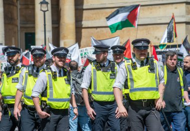 Londra, İngiltere. 14 Mayıs 2022. İngiltere 'nin orta kesimindeki Londra sokaklarında düzenlenen bir gösteri sırasında Filistin yanlısı protestoculara eşlik eden yüksek yelekli Başkent Polisi memurları.