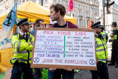 Londra, İngiltere, 19 Nisan 2019. İklim değişikliği / çevre göstericisi ve polis Oxford Circus, Londra 'daki Soykırım İsyanı gösterisinde, dünyanın iklim çöküşünü ve ekolojik çöküşü protesto etmek için.