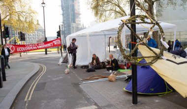 London, UK. 19th April 2019. Extinction Rebellion supporters occupy & block the road in Parliament Square, central London, with tents, in protest against world climate change and ecological collapse.