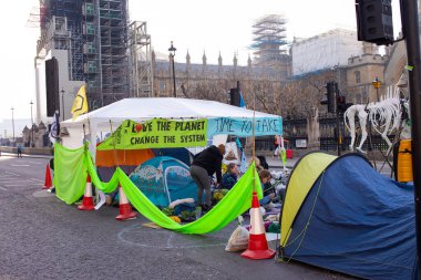 London, UK. 19th April 2019. Extinction Rebellion supporters occupy & block the road in Parliament Square, central London, with tents, in protest against world climate change and ecological collapse.