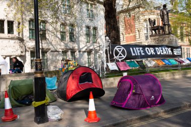 London, UK. 19th April 2019. Extinction Rebellion supporters occupy & block the road in Parliament Square, central London, with tents, in protest against world climate change and ecological collapse.