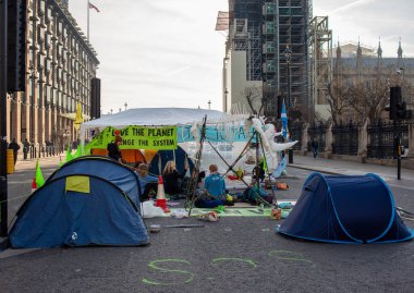 London, UK. 19th April 2019. Extinction Rebellion supporters occupy & block the road in Parliament Square, central London, with tents, in protest against world climate change and ecological collapse.