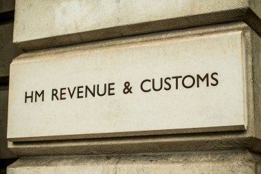 Angled close up of HM REVENUE and CUSTOMS stone sign on the exterior of government building in Whitehall, London, England.