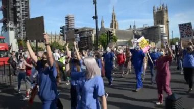 Londra, İngiltere. 29 Temmuz 2020. NHS hemşireleri ve kilit hastane çalışanları İngiliz hükümetinden adil bir maaş zammı için Londra Parlamento Meydanı 'nda yürüyüş yapıyorlar..