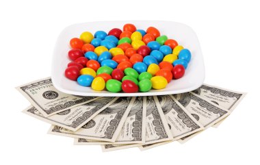 Beyaz arka plan üzerinde izole para ile plaka üzerinde renkli şeker