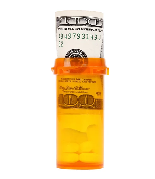 Pengar i medicin flaska med piller isolerad på vit — Stock fotografie