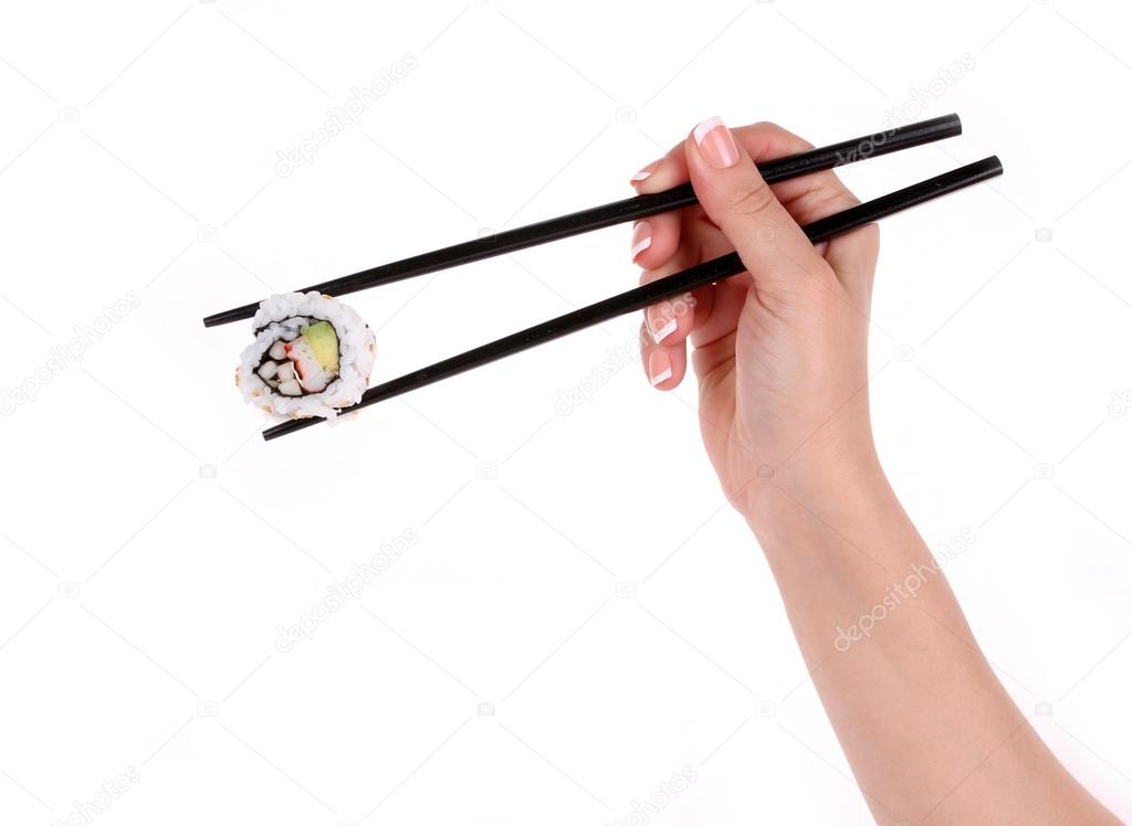 Sushi roll with black chopsticks in female hand isolated on white