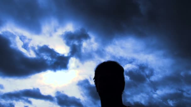 Person silhouetted raises hand into frame to give two thumbs up sign then walks out of frame. — Stock Video