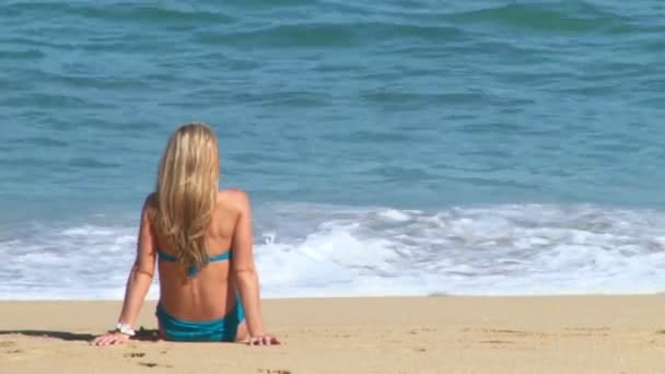 Long haired blonde woman enjoys a perfect day at the beach in Cabo San Lucas, Mexico by resort.
