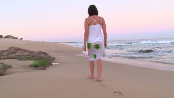 Kvinnan promenader utmed sandstranden — Stockvideo