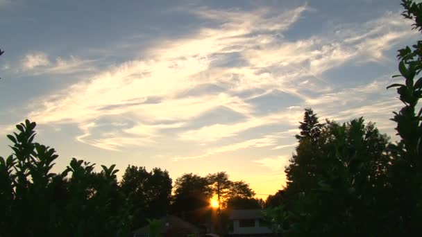 Sole va giù attraverso gli alberi al tramonto con belle nuvole time lapse . — Video Stock