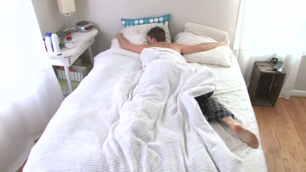 Muž se probudí a předvedení funkce snooze na poplach pak usíná. — Stock video