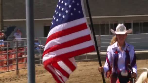 En man på en häst på en rodeo med amerikanska flaggan — Stockvideo