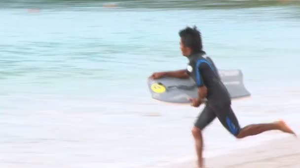 Hombre surfeando en la playa — Vídeos de Stock