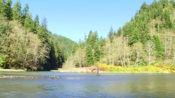 Hombre caminando sobre el agua en las montañas — Vídeos de Stock