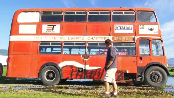 Een man loopt in de buurt van de bus — Stockvideo