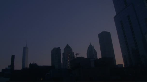O sol nasce sobre os arranha-céus na cidade grande — Vídeo de Stock
