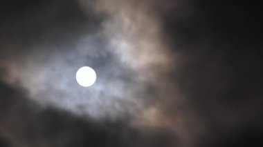 Gerçek zamanlı bulutlar parlayan dolunay ile gece gökyüzünü geçiyor..