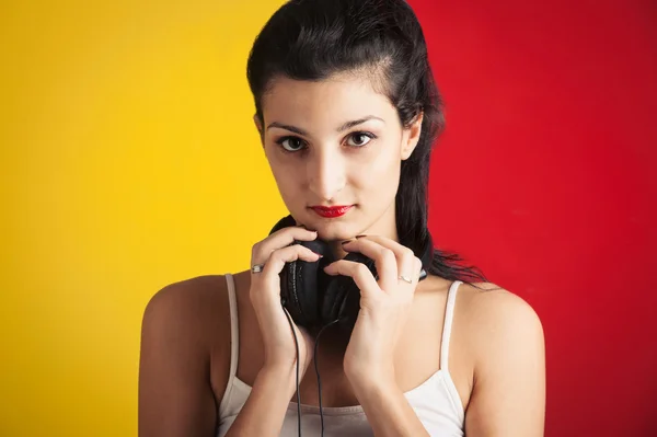 Kırmızı ve sarı backgro karşı müzik dinlemek güzel bir kız — Stok fotoğraf