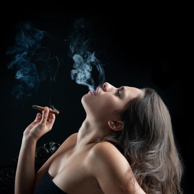 kadın sigara puro karanlık bir arka plana dayanır. Studio moda phot
