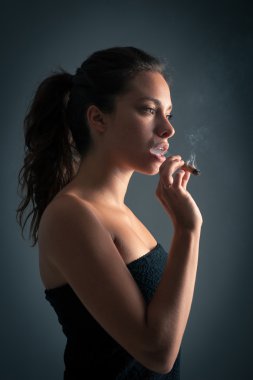 kadın sigara puro karanlık bir arka plana dayanır. Studio moda phot
