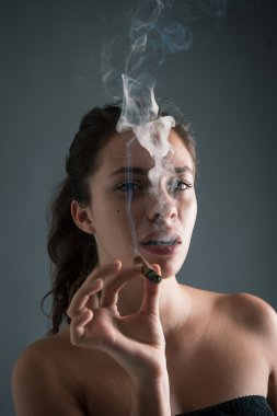 kadın sigara puro karanlık bir arka plana dayanır. Studio moda phot