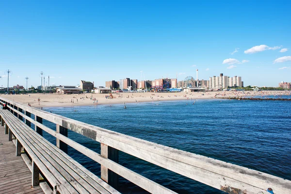 背景には、ニューヨーク市コニーアイランドのビーチと桟橋. — ストック写真