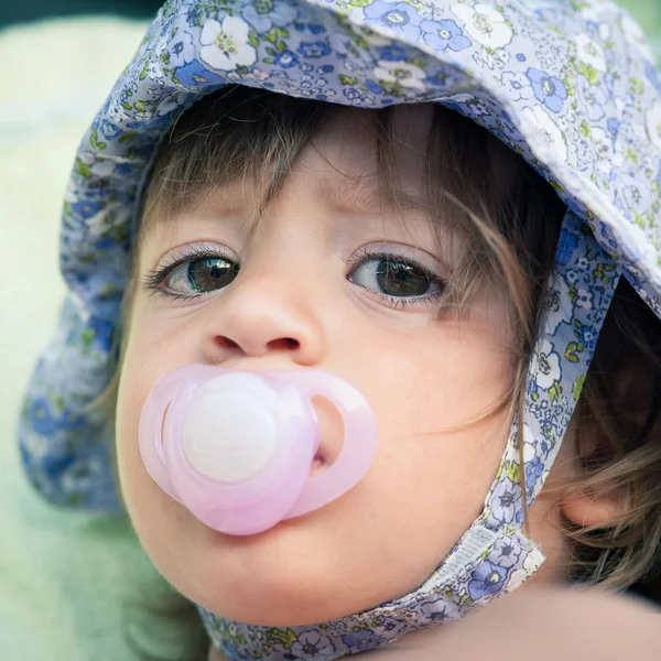 One year old girl with pacifier outdoor portrait. — Stock Photo, Image