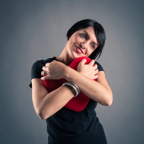 Retrato de mulher morena atraente segurando coração vermelho contra — Fotografia de Stock